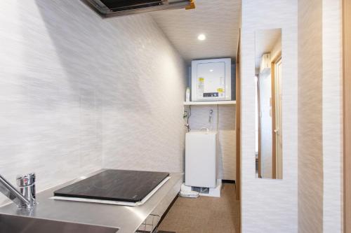 a small bathroom with a sink and a refrigerator at New open! Hopetree 京都 in Kyoto