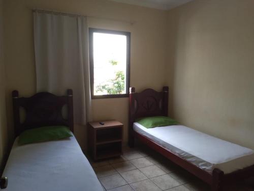 two beds in a small room with a window at HOTEL CENTER Ribeirão in Ribeirão Preto