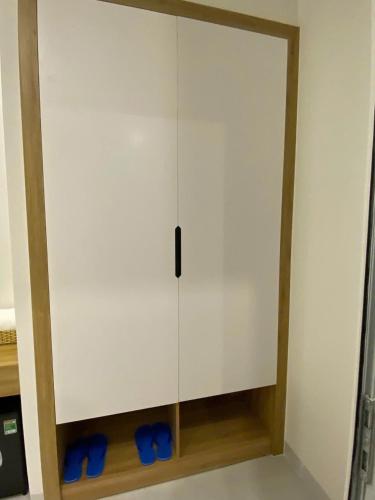 a white cabinet with blue shoes in a room at Luxury Hotel Long Thành in Xóm Nước Trong
