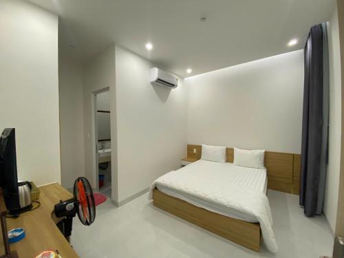 a small bedroom with a bed and a desk at Luxury Hotel Long Thành in Xóm Nước Trong
