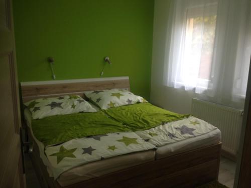 a green bedroom with a bed with stars on it at ZEN Apartman Sunshine in Zamárdi