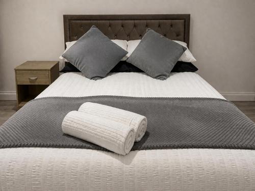 a bed with two pillows on top of it at Modern Guest house with private entrance in Manchester