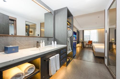 a bathroom with a sink and a tub at Mehood Hotel Xi'an Tumen Railway Station in Xi'an