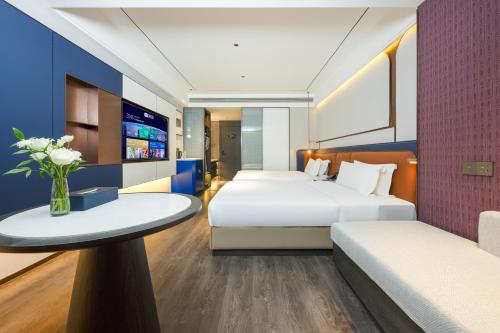 a hotel room with two beds and a table at Mehood Hotel Xi'an Tumen Railway Station in Xi'an