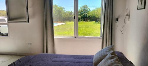 a bedroom with a window with a view of a yard at El Chiringuito in Paraná