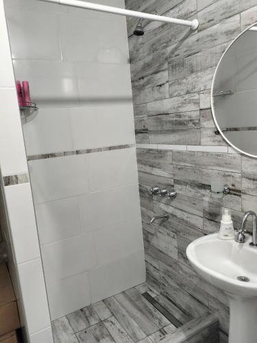 a white bathroom with a sink and a mirror at El Chiringuito in Paraná