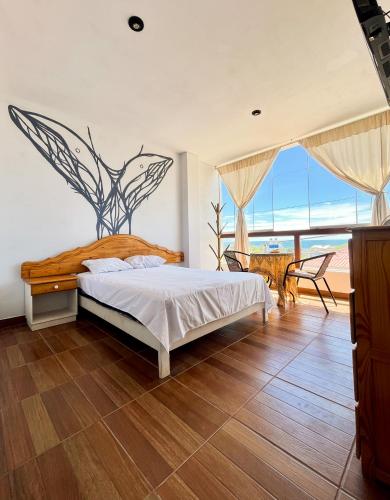 a bedroom with a bed and a view of the ocean at Casa Norte North Beach in Los Órganos