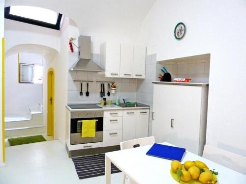 a kitchen with a table with a bowl of fruit on it at Sciù Sciù House in Atrani