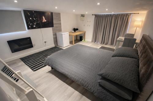 a bedroom with a large bed and a television at Modern Guest house with private entrance in Manchester