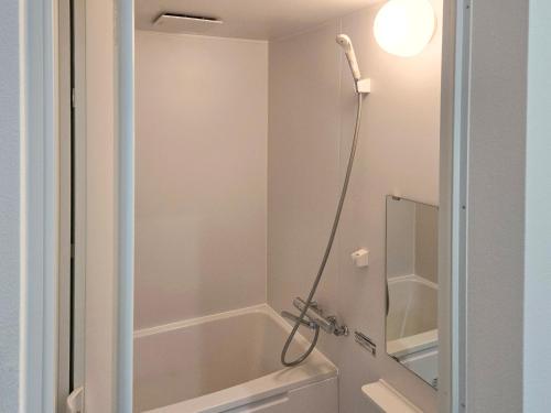 a shower in a bathroom with a bath tub at 旅館さくら in Takamatsu