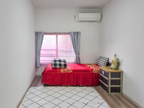 a bedroom with a red bed with a window at 旅館さくら in Takamatsu