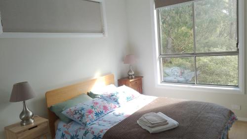 a bedroom with a bed and a window at The Piddington Top in Mount Victoria