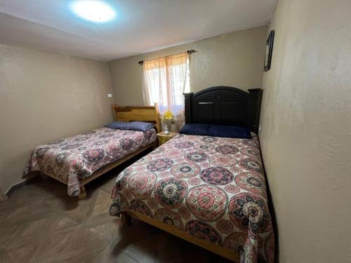 a bedroom with two beds and a window at Cabaña el Pino 1 in Creel
