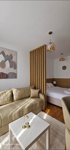 a living room with a couch and a bed at Zlatni TRG in Zlatibor