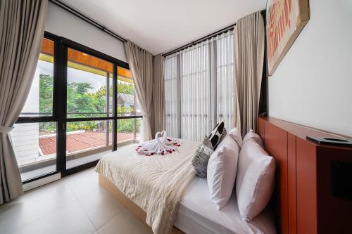 a bedroom with a bed and a large window at Villa Vatama Jimbaran in Jimbaran