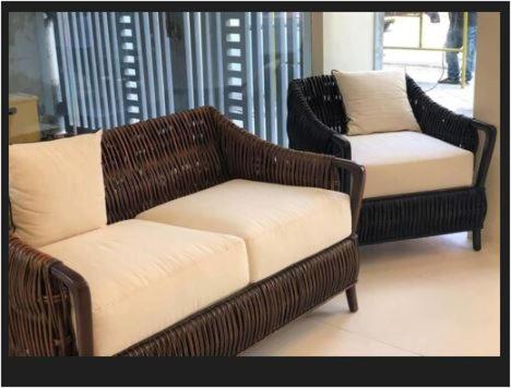 two wicker chairs and a couch in a room at Rana Hotel in Sampong