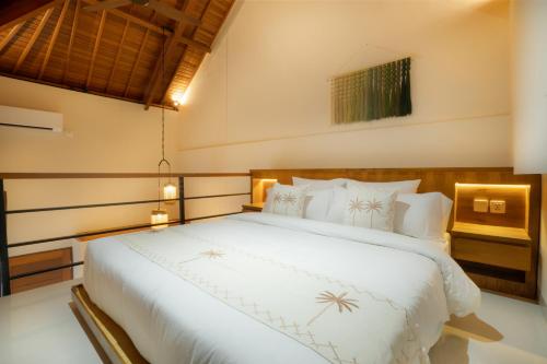 a bedroom with a large white bed in a room at Sleepwell Seminyak in Seminyak