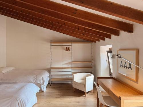 a bedroom with two beds and a desk with a chair at Manyolas 93 in Alaró
