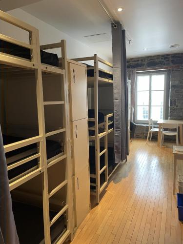 Alt Hostel في مونتريال: غرفة نوم مشتركة بها أسرّة بطابقين وطاولة