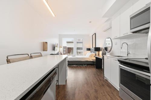 a kitchen and living room with a bed in the background at Meramont Hotel Downtown in Montreal