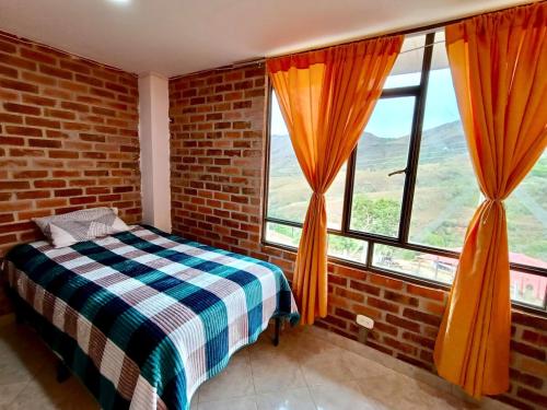 a bedroom with a bed and two windows at Casa Finca de verano in Chachagüí