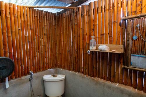 a bathroom with a toilet and a wooden wall at Vang Vieng Ban Lao Guesthouse in Vang Vieng