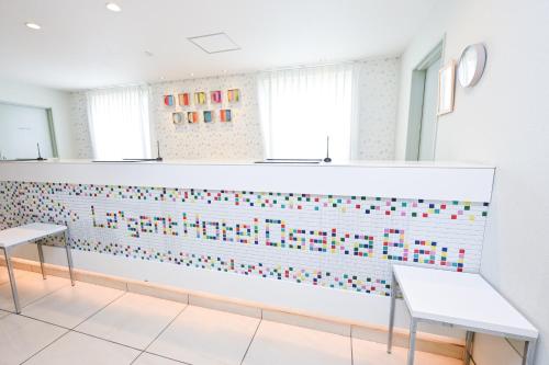 a room with two benches and a wall with colorful tiles at La'gent Hotel Osaka Bay in Osaka
