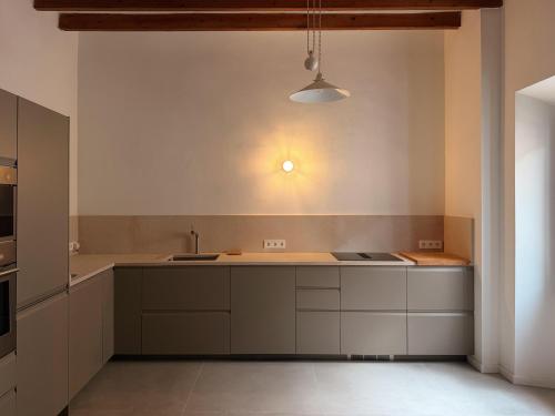 a kitchen with white cabinets and a sink at Manyolas 93 in Alaró