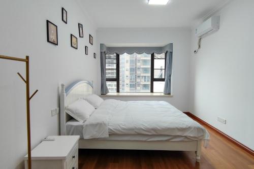 a white bedroom with a bed and a window at WeChat user-s store in Gongche