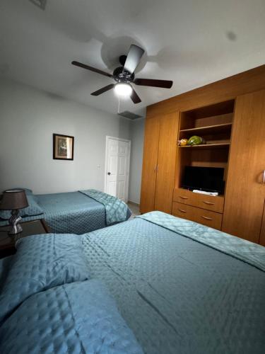 a bedroom with two beds and a ceiling fan at Villa Bonita in La Ceiba