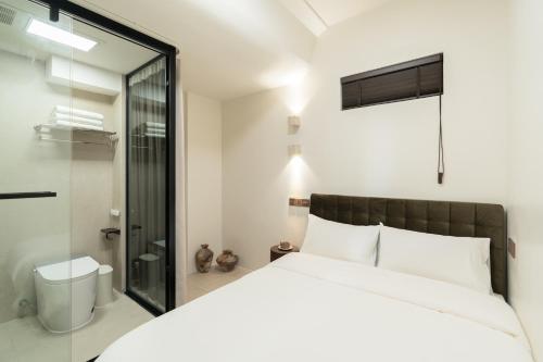 a bedroom with a large bed and a shower at XiangNanLi Atelier Suites-Chengdu Chunxi Road & Taikoo Li in Chengdu