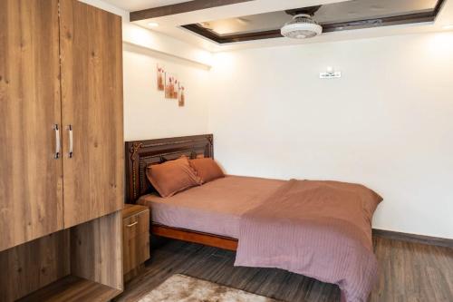 a bedroom with a bed and a wooden cabinet at Hills Pride in Nandi