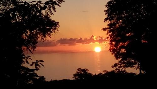 a sunset over a lake with the sun in the sky at Precious Residence C in Grand'Anse