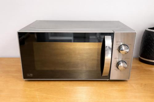 a silver toaster oven sitting on a wooden table at Modern Guest house with private entrance in Manchester
