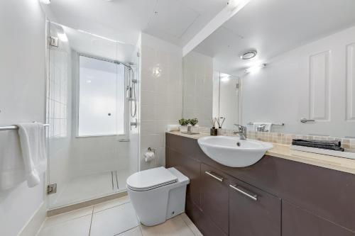 a bathroom with a toilet and a sink and a shower at Ocean Rise at Airlie Two in Airlie Beach