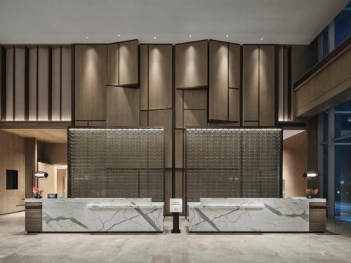 a lobby with two reception desks in a building at Doubletree By Hilton Rugao in Rugao