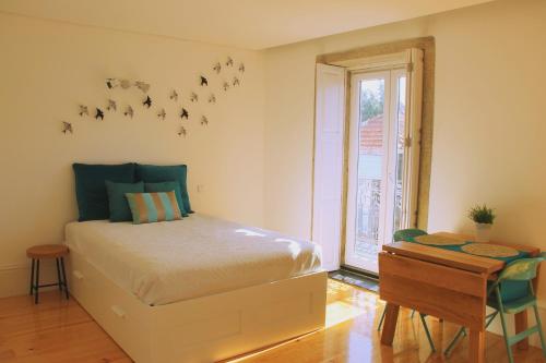 1 dormitorio con 1 cama con pájaros en la pared en Andorinha Apartment, en Oporto