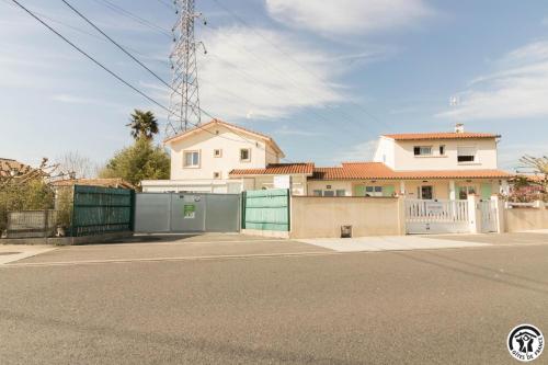a white house with a gate and a fence at Maison venitia 14 personnes in Aussonne
