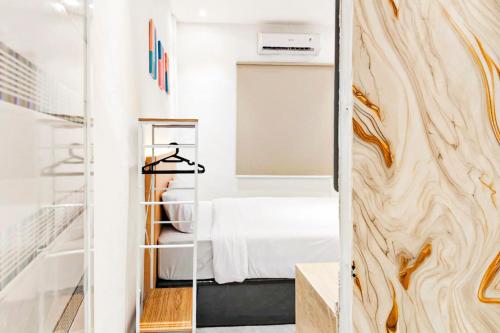 a room with a bed and a mirror at Adi Inn Homestay RedPartner in Sunggal