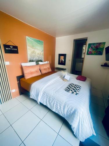 a bedroom with a large bed with orange walls at Domaine Maud-Jardin de Maud ! 100m plage in Saint-Pierre