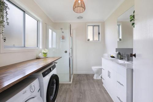 a bathroom with a washer and dryer in it at Jimley Cottage in Warrnambool