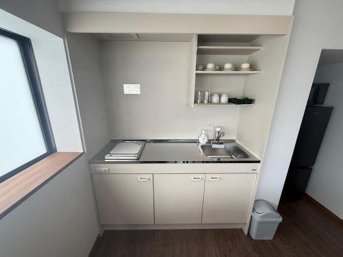 a small kitchen with a sink and a window at Lento Stay HAGI in Hagi