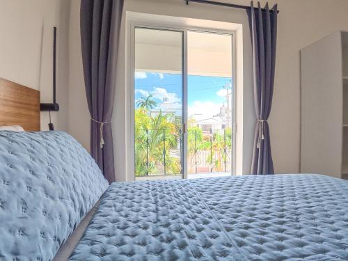 a bedroom with a bed and a large window at TAYGA STUDIOS Cancun in Cancún
