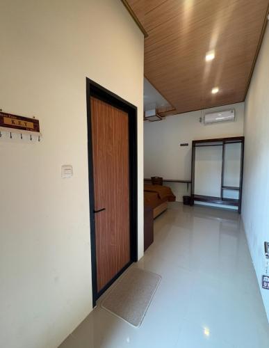 an empty room with a door and a couch at Loko Stay Syariah in Krui
