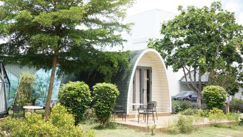 a house with a table and chairs in a yard at VinaEcolife Lodge in Ba Tri