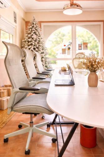 a row of desks in a room with a christmas tree at Alter Space Workspace and CoLiving in General Luna