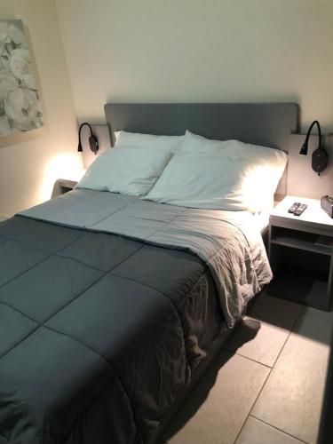 a bedroom with a bed and a table with a lamp at Hibiscus House in Bequia