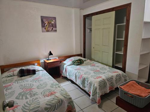 a bedroom with two beds and a door with a mirror at Apartamento 3 TEC in Cartago