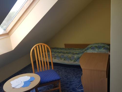 a bedroom with a bed and a chair and a table at Dom Pod Dębami in Wola Kopcowa