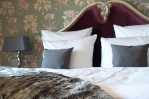 a bedroom with a bed with white sheets and pillows at Rittergut Rottewitz in Meißen